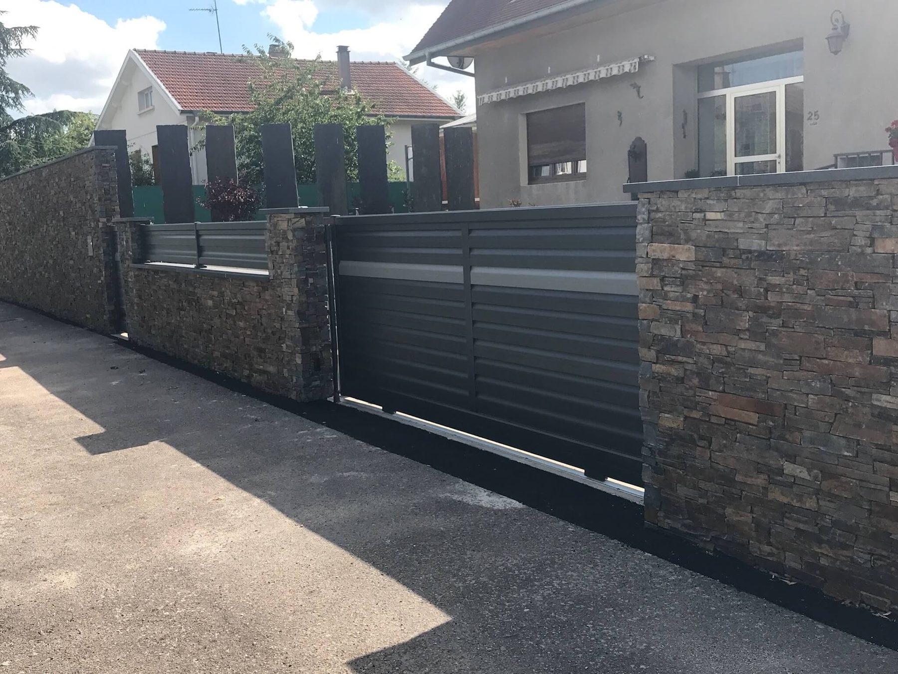 Mur en pierre de parement et portail coulissant anthracite