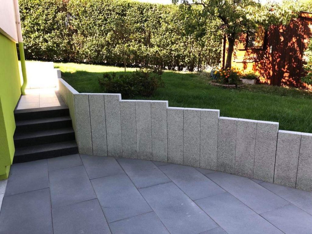 Mur de soutien en palissades de granit et dallage gris
